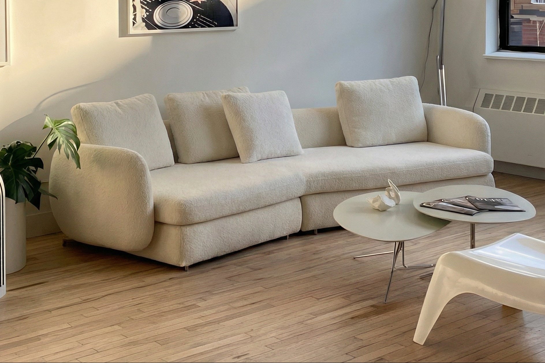 Modern living room with a beige sofa, coffee table, and decorative items.